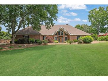 Sprawling brick home with an expansive lawn and mature trees offering a tranquil setting at 5950 Meadow Brook Ln, Cumming, GA 30040