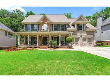 Charming two-story home with a well-manicured lawn, covered porch, and attached two-car garage at 5652 Harbormist Dr, Powder Springs, GA 30127