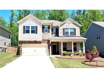 Beautiful two-story home with a combination of brick and siding, landscaped yard and a two car garage at 1835 Wellston Dr, Lawrenceville, GA 30043