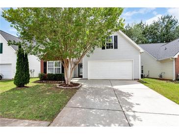 Charming home featuring a two-car garage and a well-maintained front yard with mature landscaping at 285 Kentshire Pl, Lawrenceville, GA 30044
