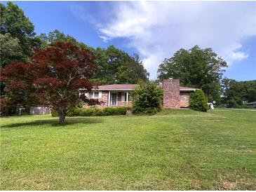 Quaint single-story brick home with a neatly maintained lawn and mature landscaping at 4179 Westview St, Douglasville, GA 30135