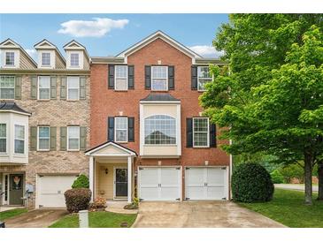Charming brick townhome featuring a two-car garage and well-maintained landscaping at 200 Valley Xing, Canton, GA 30114