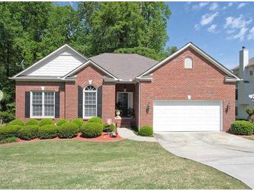 Charming single-story brick home featuring a two-car garage and well-manicured lawn with lush landscaping at 361 Brackin Trce, Grayson, GA 30017