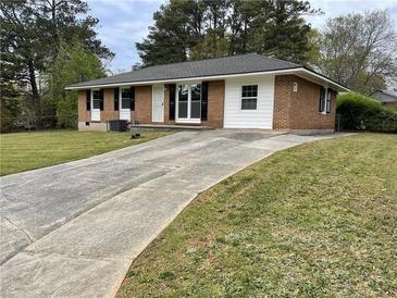 Quaint brick home featuring a long driveway and a well-maintained front yard at 6927 Eunice Dr, Riverdale, GA 30274