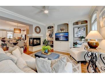 Inviting living room featuring a fireplace, hardwood floors, and built-in shelving at 7435 Jamestown Dr, Alpharetta, GA 30005