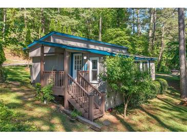 Charming exterior view of home with a cozy front porch and natural, wooded surroundings at 135 Marina Ct, Canton, GA 30114