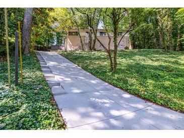 Suburban home with a large yard, driveway, and mature trees at 1583 Nantahalla Ne Ct, Atlanta, GA 30329