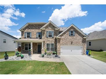 Charming two-story home features a stone and brick facade, a two-car garage, and a well-manicured front yard at , Atlanta, GA 30349