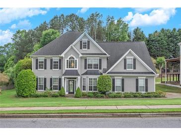 Charming two-story home with a well-manicured lawn, lush greenery, and traditional architectural details at 225 Ruby Forest Pkwy, Suwanee, GA 30024