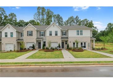 View of new construction townhomes featuring manicured lawns and sidewalks at 320 Navigator Ln, Mcdonough, GA 30253