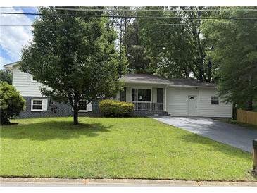 Charming single-story home with a lush green lawn and a paved driveway at 5460 Huron Dr, Morrow, GA 30260