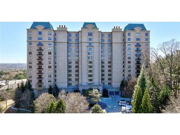 Elegant condominium building with beautiful landscaping and a circular driveway at 2700 Paces Ferry Se Rd # 202, Atlanta, GA 30339
