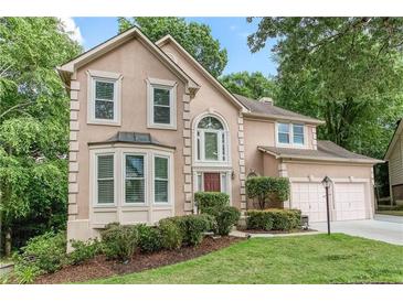 Charming two-story home featuring a well-manicured lawn, lush landscaping, and inviting curb appeal at 58 Parkside Cir, Marietta, GA 30068