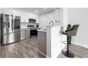 Modern kitchen features stainless steel appliances, gray cabinets, and breakfast bar with a stool at 2657 Lenox Ne Rd # A-5, Atlanta, GA 30324