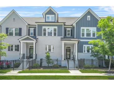 Charming townhomes with gray and white brick, black trim, fenced yards, and well-manicured landscaping at 2744 Bell Se Dr, Smyrna, GA 30080