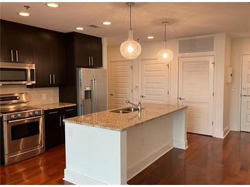 Modern kitchen with granite countertops, stainless steel appliances, and dark wood cabinets at 1080 Peachtree Ne St # 2915, Atlanta, GA 30309