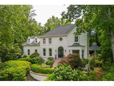 Stunning two-story home with a black door, pristine white exterior, and expertly landscaped front yard at 341 Lands Se Ml, Marietta, GA 30067