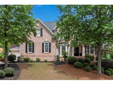 Charming two-story brick home with a well-manicured lawn and mature trees, offering great curb appeal at 2020 Windermere Xing, Cumming, GA 30041