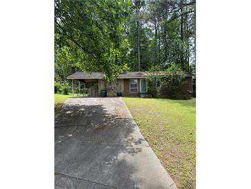 Charming single-story home with stone accents, a covered parking area, and a lush green lawn at 1234 Carolyn St, Marietta, GA 30062