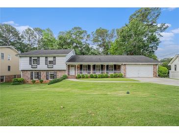Charming home with a brick and white facade, a well-manicured lawn, and a welcoming front porch at 2855 Cedar Canyon Ct, Atlanta, GA 30345