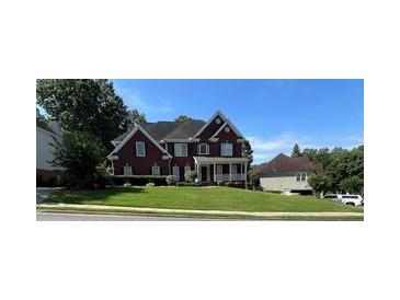 Charming two-story brick home featuring a manicured lawn and inviting front porch at 3305 Millwater Xing, Dacula, GA 30019