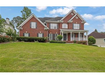 Charming two-story brick home with a well-manicured lawn, covered porch, and black shutters at 3305 Millwater Xing, Dacula, GA 30019