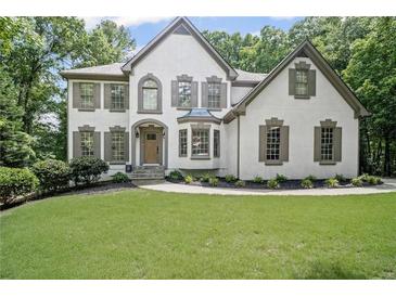 Charming two-story home with a manicured lawn and inviting curb appeal surrounded by lush greenery at 2535 Hampton Trl, Cumming, GA 30041