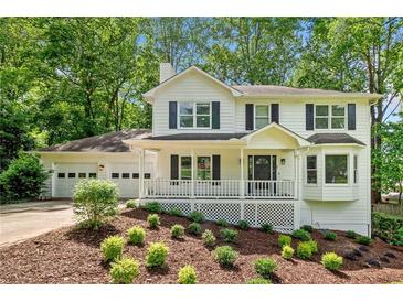 Charming two-story traditional home with a welcoming front porch and a well-manicured, landscaped front yard at 3078 Milford Chase Sw, Marietta, GA 30008