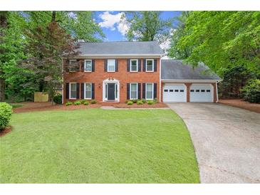 Charming two-story brick home with well-manicured lawn and a three-car garage at 4504 Reva Ne Way, Marietta, GA 30066