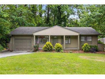 Charming home featuring a well-manicured lawn, complemented by lush greenery, offering a welcoming curb appeal at 2343 Poplar Springs Ne Dr, Brookhaven, GA 30319