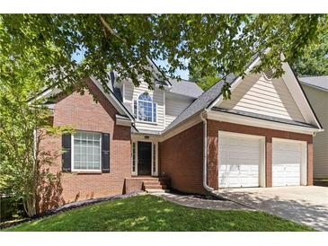 Charming two-story brick home with attached two-car garage and manicured lawn at 1620 Concord Meadows Dr, Smyrna, GA 30082