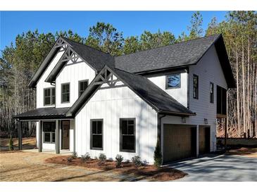 Beautiful, new two-story home with white siding, black trim, and a two-car garage with attractive landscaping at 3785 Pilgrim Mill Rd, Cumming, GA 30041