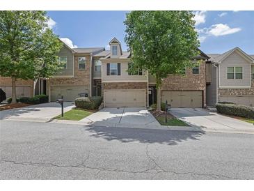 Attractive townhomes featuring a two-car garage, manicured landscaping, and neutral exterior colors at 4965 Whiteoak Se Walk # 19, Smyrna, GA 30080