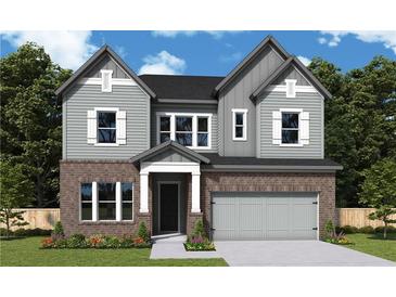 Charming two-story home featuring a brick facade, gray siding, and an attached two-car garage at 4720 Briscoe Drive, Cumming, GA 30028