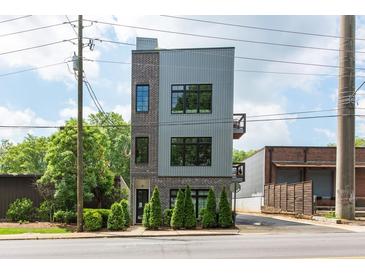 Contemporary three-story home featuring mixed brick and metal siding with black framed windows at 417 E College Ave # 102, Decatur, GA 30030