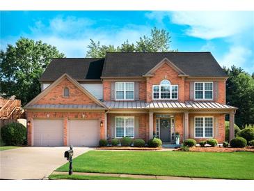 Charming brick home featuring a well-manicured lawn and a two-car garage at 5281 Tormeall Trce, Suwanee, GA 30024
