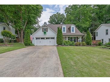 Charming one-story home with white siding, dormer windows, attached garage, and well-manicured lawn at 115 Ocee View Ct, Alpharetta, GA 30022