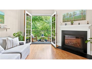 Bright living room with hardwood floors, fireplace, and balcony with green view at 351 Washington Ne Ave # 205, Marietta, GA 30060