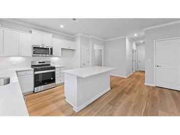 Modern kitchen featuring stainless steel appliances, white cabinets, and a center island at 401 Village Ln, Fairburn, GA 30213