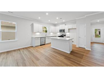 Bright kitchen with an island, stainless steel appliances, and ample counter space at 401 Village Ln, Fairburn, GA 30213