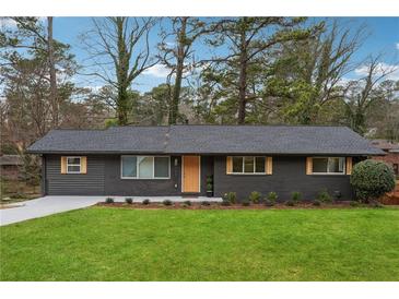Charming one-story home with a well-manicured lawn and newly painted dark gray exterior with wooden accents at 1667 Atherton Cir, Decatur, GA 30035