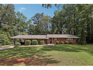 Charming one-story brick home with lush green lawn and mature trees offering great curb appeal at 112 Pioneer Trail, Cartersville, GA 30121