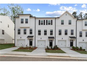 Charming three-story townhomes featuring attached garages, manicured lawns, and crisp white siding at 3142 Washburn St, Atlanta, GA 30354