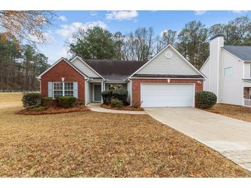 Charming single-story home with a well-maintained lawn and a two car attached garage at 2457 Swan Lake Dr, Grayson, GA 30017