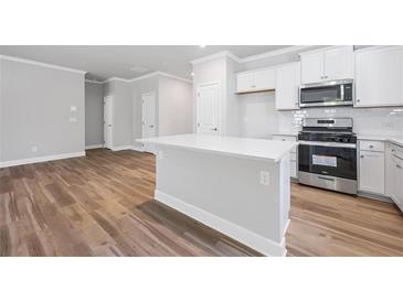 Modern kitchen with a central island, stainless steel appliances, and hardwood floors at 470 Village Ln, Fairburn, GA 30213