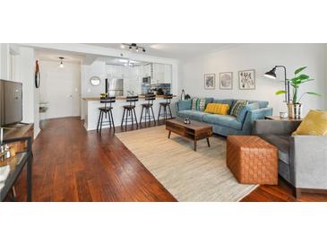 Bright living room with modern furnishings, hardwood floors, and an open layout to the kitchen at 620 Peachtree Ne St # 403, Atlanta, GA 30308