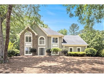 Charming home featuring stone accents, arched windows, manicured landscaping, and a well-maintained lawn at 1198 Larson Sw Ln, Marietta, GA 30064