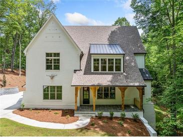 Charming white brick two-story home with covered porch and manicured landscaping at 2585 Hickory Rd, Canton, GA 30115