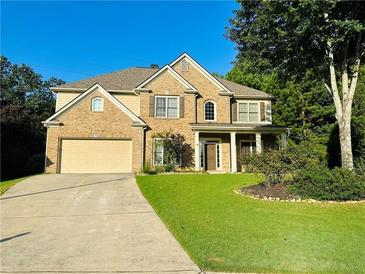 Traditional brick two-story home with a manicured lawn and attached two-car garage in a suburban setting at 3200 Emma Marie Pl, Buford, GA 30519