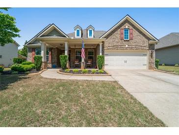 Charming brick home with a covered front porch and well-manicured landscaping at 813 Cotton Creek Dr, Canton, GA 30115